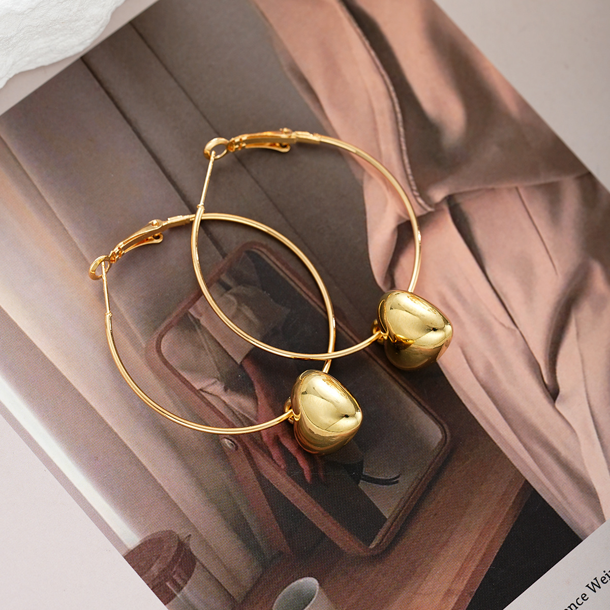 Multiple views of gold heart hoop earrings, showcasing the lightweight, hollow heart