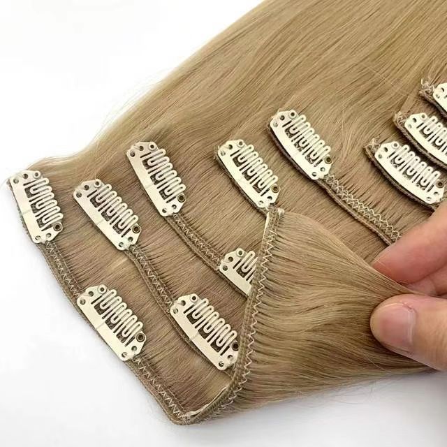 Hand holding clip-in hair extensions, showcasing the multiple wefts and secure clip design.