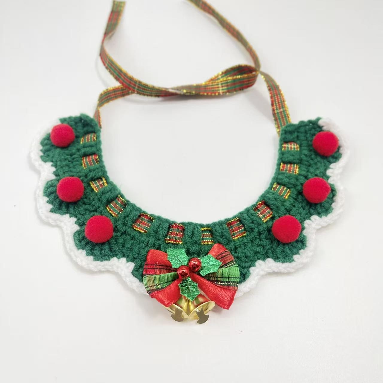 Green and red crochet pet collar with a central flower and pom-poms, displayed to show the adjustable slip-knot design