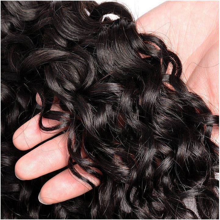 Close-up of water wave hair bundles with golden caps, highlighting the soft, bouncy texture and thick ends.