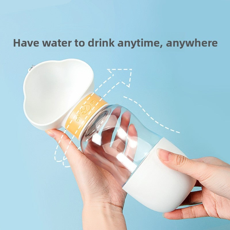 White portable pet water bottle being used to dispense water for a dog, demonstrating one-hand operation