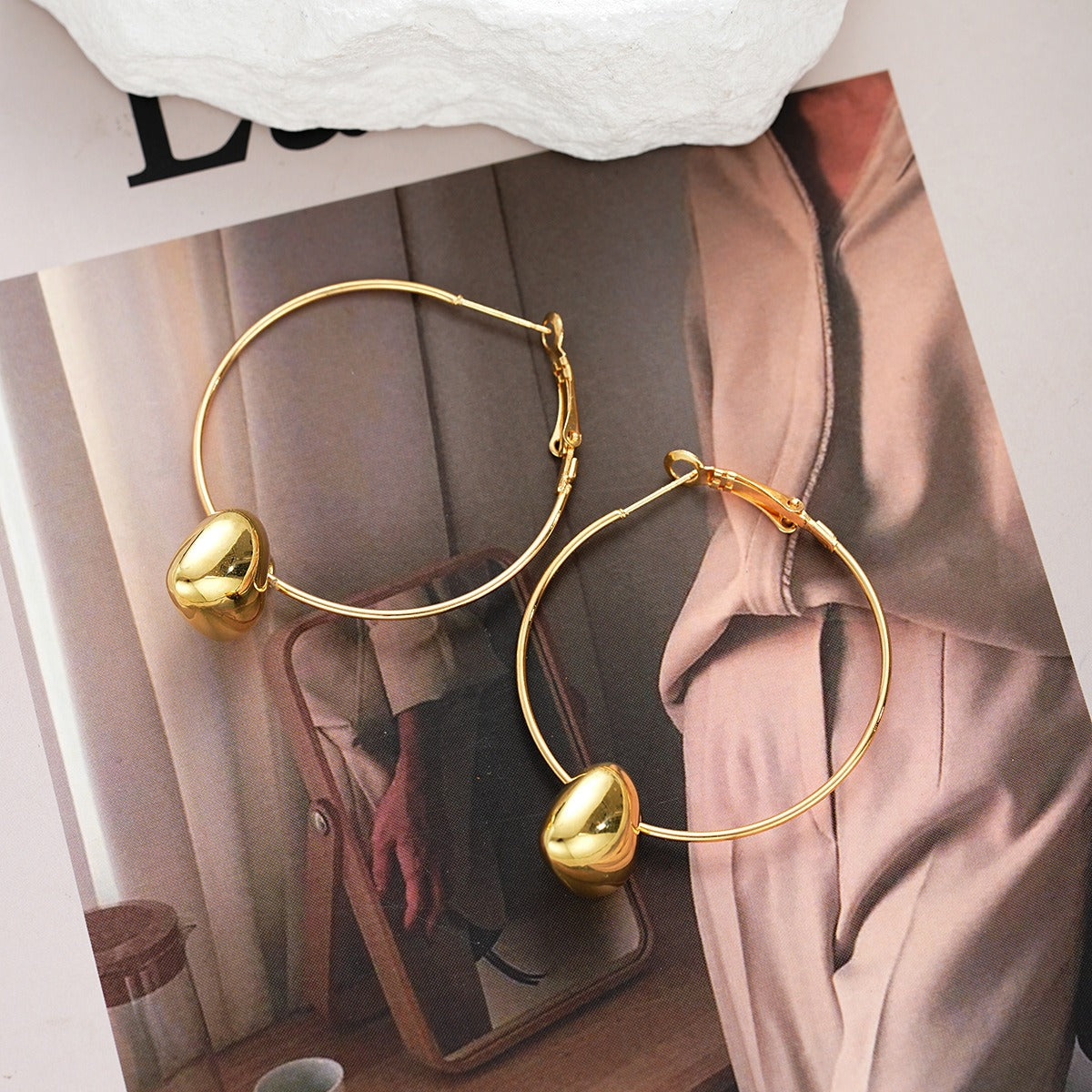 Gold heart hoop earrings worn on a model, highlighting the chic, minimalist design