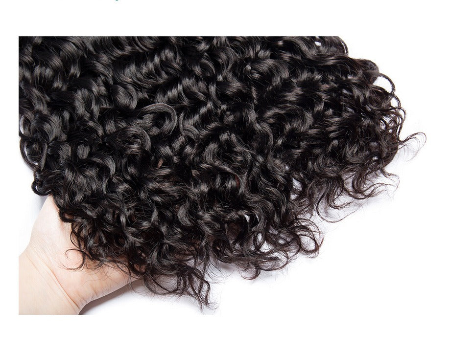 Close-up of water wave hair being held in a hand, showing the tight, defined curls and soft texture