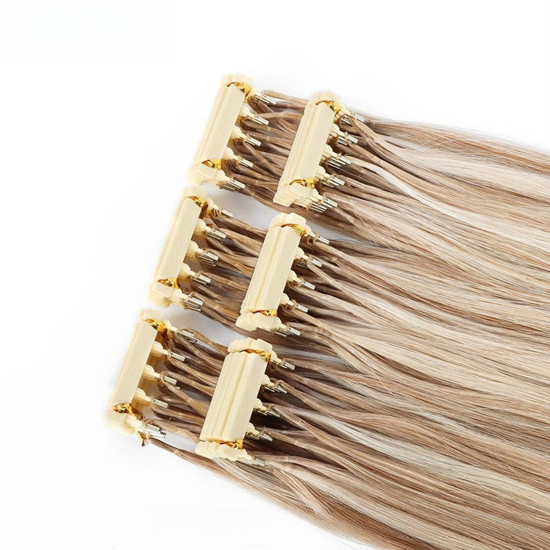Close-up of 6D Generation 1 human hair extension weft with golden applicator clips and straight light blonde hair strands