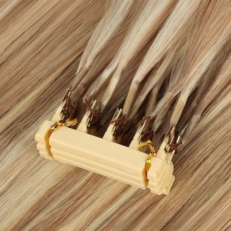 Close-up of 6D applicator tool attached to light brown straight human hair extensions