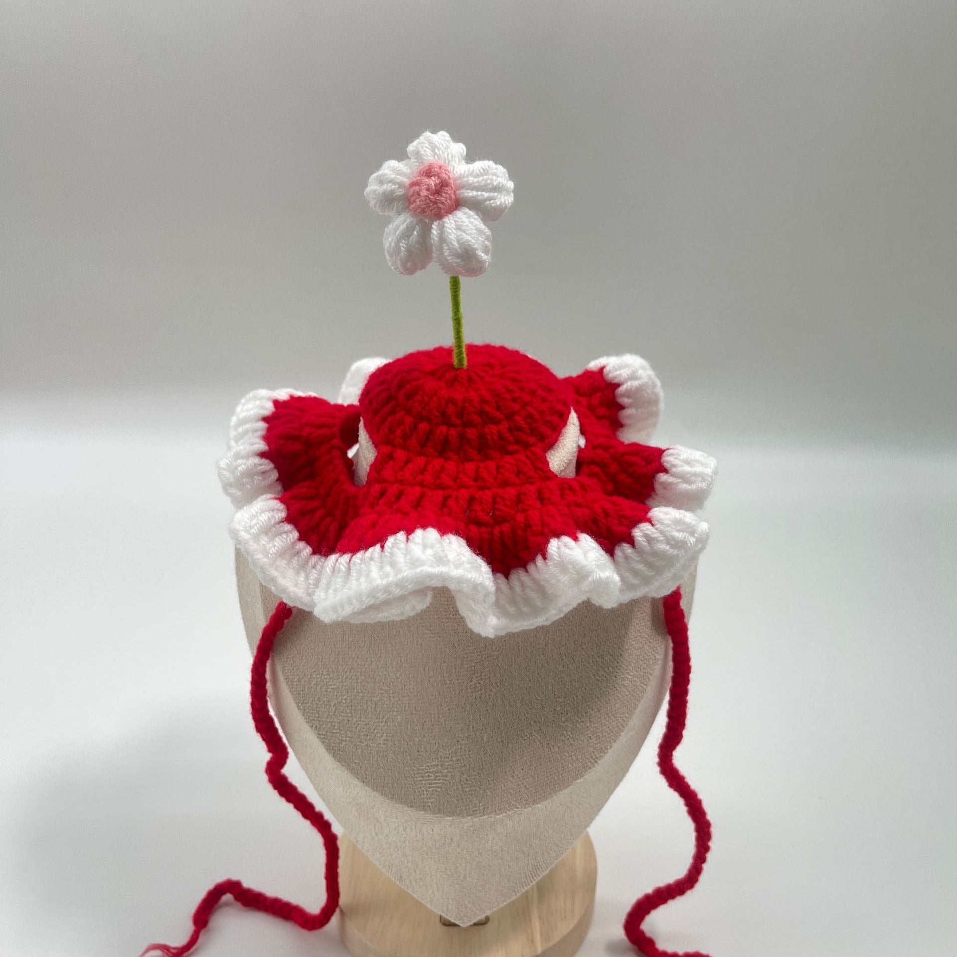 Red plush pet birthday cake hat with a decorative topper, great for birthday parties.