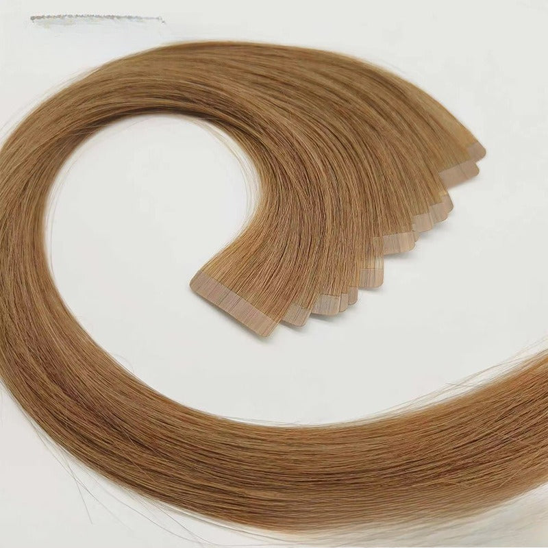 A loop of light brown tape-in hair extensions, demonstrating flexibility and natural movement.